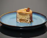 Tranche d'entremet aux couches aériennes, surmontée d'un glaçage caramel et d'une noisette croquante. Le biscuit noisette pour entremet offre une texture légère et savoureuse.