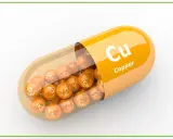 Pomarańczowa kapsułka z wysypującymi się z niej kulkami z napisem "Cu Copper". Suplement diety.