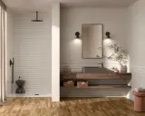 Bagno moderno con doccia a vista, lavabo in pietra e mensole in legno. Un esempio di idee bagno originali con un tocco naturale.