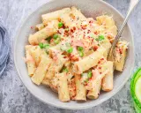 Pyszne danie z makaronem rigatoni, kawałkami łososia, groszkiem i kremowym sosem, posypane serem i płatkami chili. Idealna pasta z łososia na obiad.