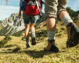 Dobre buty w góry latem to podstawa. Para wędrowców w solidnych trekkingowych butach i skarpetach pokonuje górski szlak.