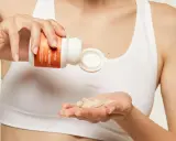 Une main verse des comprimés de vitamine C dans l'autre main, pour une cure revitalisante.