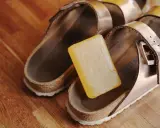 Kostka mydła obok sandałów Birkenstock, gotowa do czyszczenia.