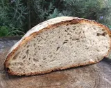 Une mie aérée et une croûte dorée pour ce pain au levain rapide, posé sur une tranche de bois.