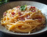 Pyszna carbonara z boczkiem i parmezanem, posypana świeżo mielonym pieprzem. Idealny przepis na szybki obiad.