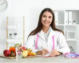Dietetyczka z miarką i owocami na biurku. Rozważa, jak wzmożony apetyt a nowotwór mogą być powiązane.