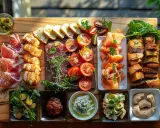 Une planche apéro généreuse : jambon cru, saumon fumé, tomates, pains variés, houmous, olives. Une belle idée planche apéro pour partager.