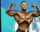Ein Bodybuilder präsentiert seine Muskeln auf der Bühne des Classic Physique Olympia.