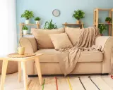 Un plaid douillet drapé sur un canapé beige, invitant à la détente. Idéal pour savoir comment mettre un plaid sur un canapé avec style.