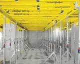 Sistema de apeo estructural Doka H20 top, con puntales metálicos y vigas amarillas, listo para soportar una losa.