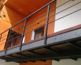 Nowoczesna balkon konstrukcja z czarną balustradą i drewnianymi elementami domu.