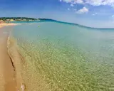 Spiaggia delle Maldive in Puglia: sabbia dorata, acque cristalline e un cielo azzurro con nuvole bianche. Un paradiso terrestre.