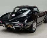 Un clásico Corvette Stingray negro, un ícono de los muscle cars americanos, con su distintiva silueta y detalles cromados.