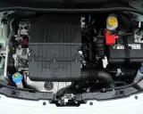 Silnik Fiata 500 L z widocznym logo FIAT na czarnej obudowie. Widać akumulator, płyny i elementy układu chłodzenia.
