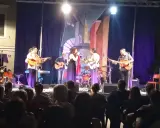 Concerto dal vivo con chitarre acustiche e voce, gli accordi di Bamboléo risuonano nell'aria.