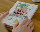 Książka "Pierwsza miesiączka" z ilustracjami dziewczynek, która odpowiada na pytanie, w jakim wieku dziewczynki dostają okres.