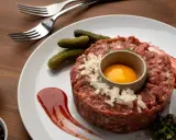 Tartar de salchichón: carne picada, huevo, pepinillos, cebolla, alcaparras y salsa. ¡Ingredientes perfectos para un plato delicioso!