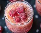Une coupe de soupe de champagne originale, garnie de framboises givrées et pétillante.