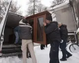Mężczyźni wynoszą mebel z domu, by uniknąć eksmisji. Zimowa aura i śnieg nie powstrzymują przeprowadzki.