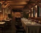 Ambiente acogedor de parrilla argentina nuevos aires. Mesas puestas, vigas de madera y luces cálidas invitan a disfrutar.
