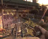 Gracz trzyma granat, otoczony przez hordę zombie na torach kolejowych. To scena z gry Dying Light, gdzie wymagania sprzętowe są kluczowe dla płynności rozgrywki.