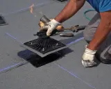 Instalador aplica calor con soplete para fijar tela asfáltica a base de techo, asegurando impermeabilización.