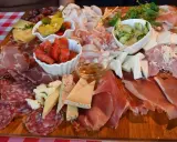 Tagliere ricco con salumi, formaggi, pomodori e sottaceti, un assaggio dei piatti tipici del Friuli Venezia Giulia.