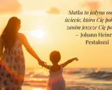 Matka z dzieckiem trzymają się za ręce na plaży o zachodzie słońca.