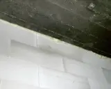 Piana montażowa, która jest rodzajem **elastomery**, uszczelnia połączenie między betonową belką a białymi bloczkami.