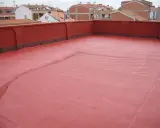 Tejado con acabado rojo, recién aplicado un slurry que es una capa protectora.