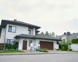 Rodzina spaceruje przed nowoczesnymi projektami domów piętrowych.