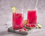 Cocktail fruité et rafraîchissant, ce cocktail fruit du dragon est garni de quartiers de citron vert et de graines de grenade.