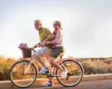 Pareja mayor disfruta de un paseo en bicicleta, celebrando la jubilación a los 61 años con la nueva reforma.