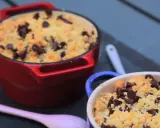 Deux ramequins de crumble pomme banane chocolat, l'un rouge, l'autre bleu, garnis de pépites de chocolat.