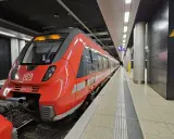 Röd DB-tåg på en station, redo att ta dig från berlin flygplats till centrum.
