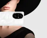 Primo piano di un telefono Honor bianco con un'elegante donna sullo sfondo, che evoca un effetto ritratto foto.