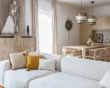 Jasny salon z sofą, stołem i krzesłami w stylu modern organic.