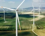 Weite Felder mit vielen weißen onshore Windkraftanlagen unter blauem Himmel.