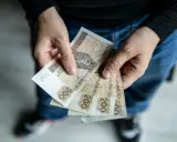 Dłonie trzymają banknoty 200 zł. Czy to odpowiedź na pytanie: 800 plus dla kogo?