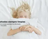 Niña rubia duerme abrazada a una almohada blanca. Consejos sobre como lavar almohadas para que estén frescas e impecables.