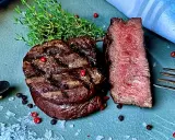 Perfekt gegrilltes Rinderfilet mit zarten rosa Kern, garniert mit Thymian, Pfeffer und grobem Salz. Ein Genuss für Fleischliebhaber!