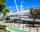 Moderne Architektur auf dem Expo Gelände Lissabon mit einem langen, geschwungenen Dach und Glasfassaden.