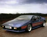 Niebieski Lotus Esprit Turbo Essex z czerwonymi pasami na boku, zaparkowany na drodze.