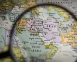 Mapa świata pod lupą, widoczne kraje Bliskiego Wschodu i Azji Południowej. W centrum Iran, Irak, Arabia Saudyjska.