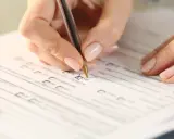 Dłoń zaznacza "TAK" na formularzu, co może być krokiem w procesie, jak uzyskać stopień niepełnosprawności.