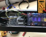Le fusible de la trottinette électrique est ici, près des connexions de la batterie. Un multimètre est visible.