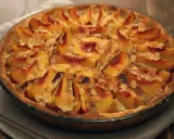 Tarte aux pêches amande, une gourmandise dorée aux fruits fondants et éclats d'amandes effilées, prête à être dégustée.