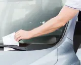 Un hombre saca una multa de tráfico del parabrisas. Si no pagas, te preguntas qué pasa si no pago una multa de tráfico.