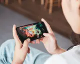 Osoba gra w ekscytujące gry multiplayer na telefonie, walcząc z potężnym przeciwnikiem.