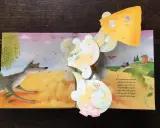 Libri pop-up più belli: un lupo soffia su una casetta di paglia, mentre un maialino corre verso una casetta di legno.